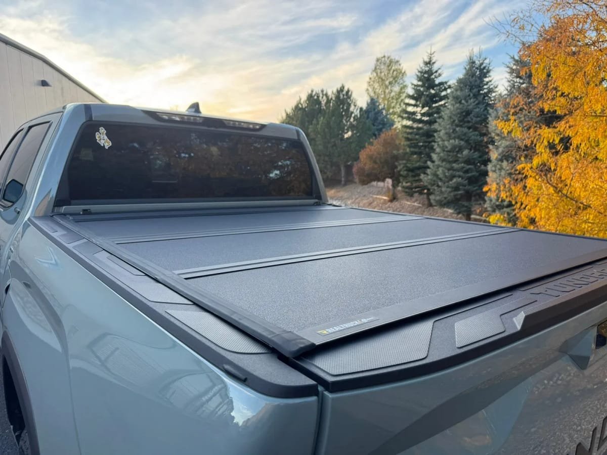 A late-model pickup truck with a professionally installed low-profile tri-fold bed cover.