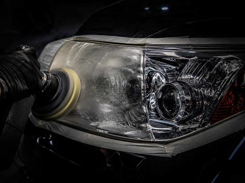 Professional headlight restoration in progress — polishing oxidized headlight lens at Adams Auto Restyling in Windsor, CO
